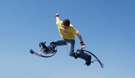 Een rijder in de lucht op Skyrunner-springstelten tegen een strakblauwe hemel